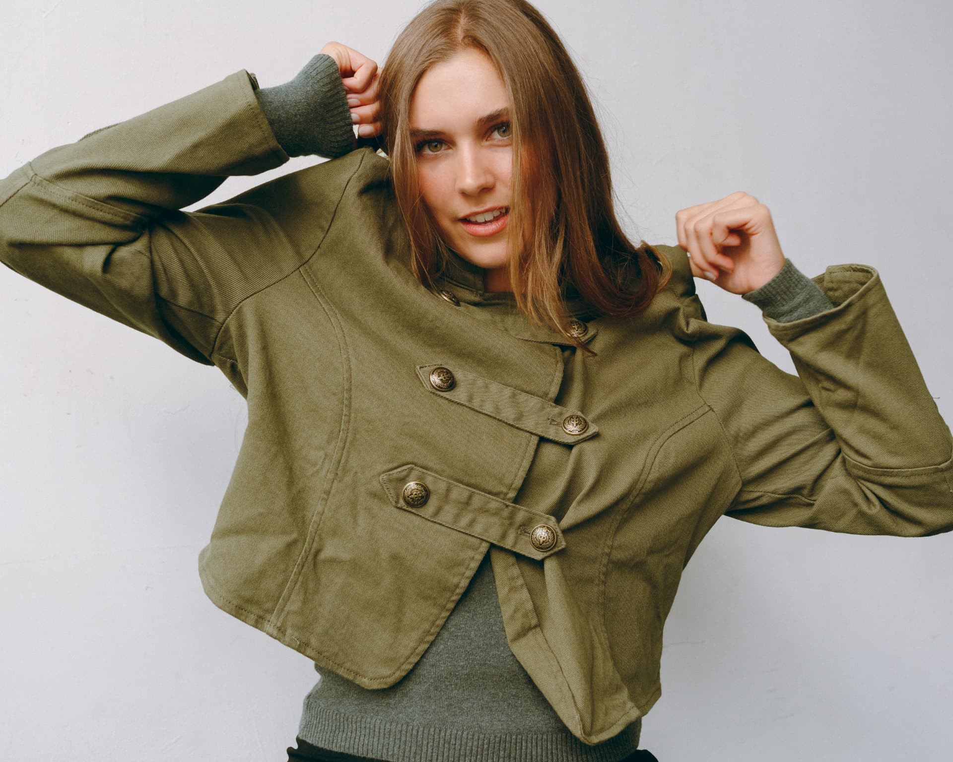 Cropped olive military jacket, hands in hair