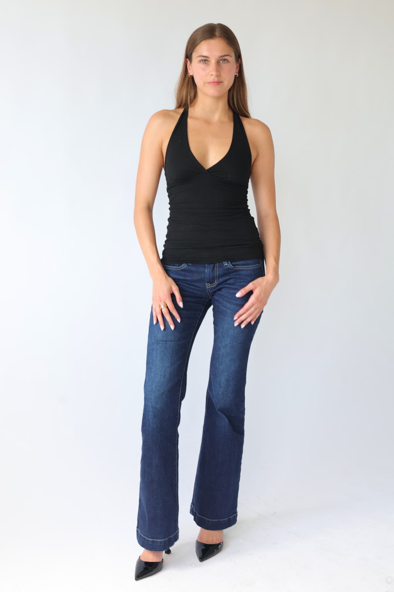 Full length agency digital in a black halter top and dark flared denim